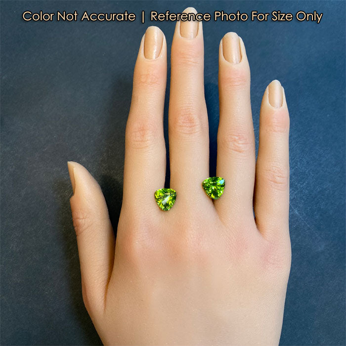 hand size reference of trilliant peridot gemstones