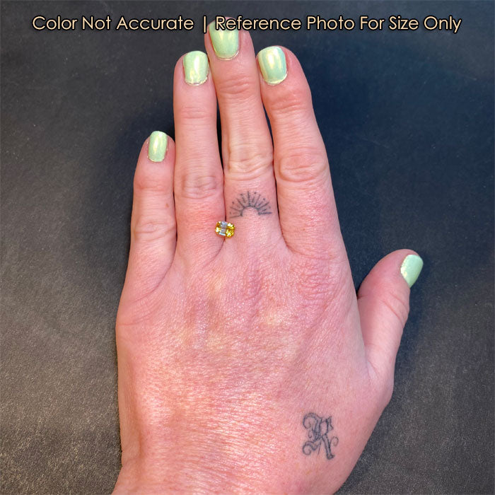 emerald cut bicolor sapphire size to hand