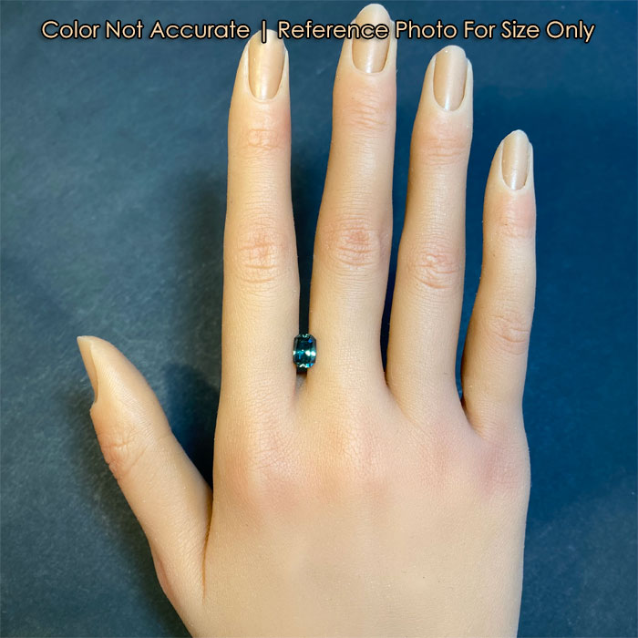 size of blue green Montana sapphire gemstone on hand