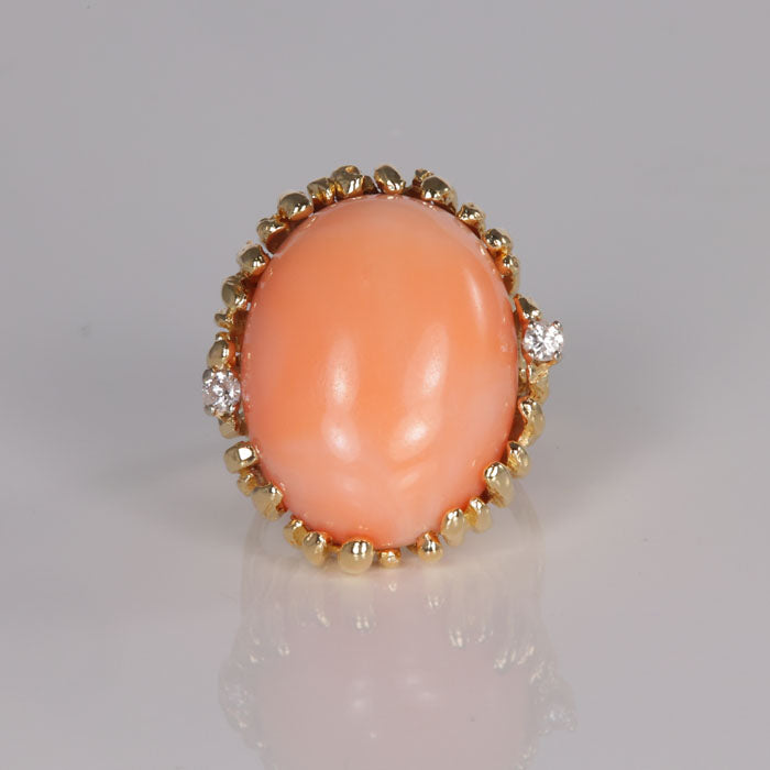 oval cabochon cut coral ring in yellow gold with diamond accents