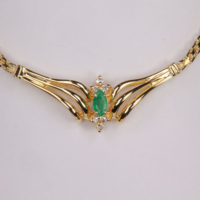 marquise cut emerald in yellow gold with diamond accents