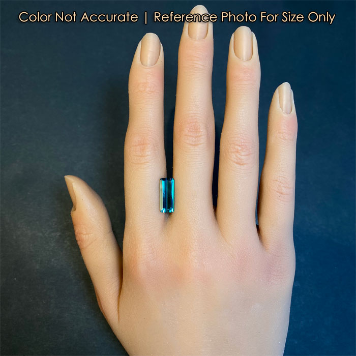 greenish blue tourmaline gem on hand