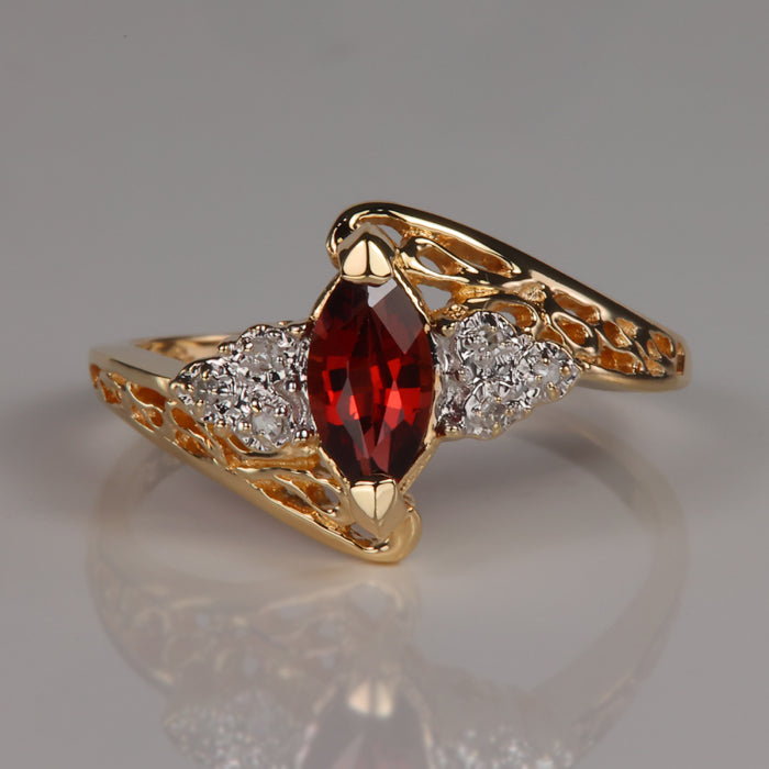 yellow gold ring with red marquise cut garnet gemstone and diamond accents