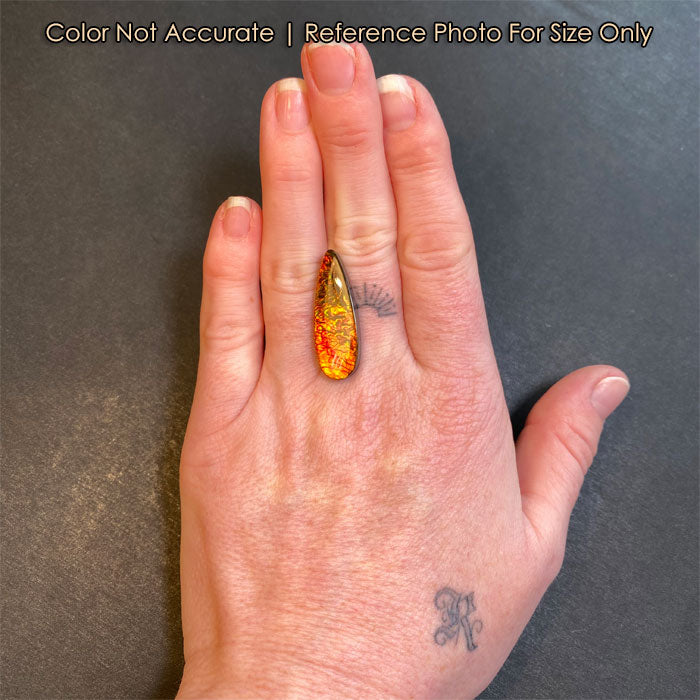 pear shaped ammolite gemstone on hand