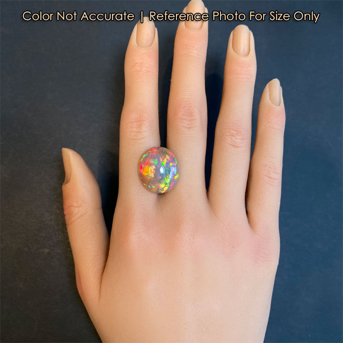 oval cabochon semi black opal on hand