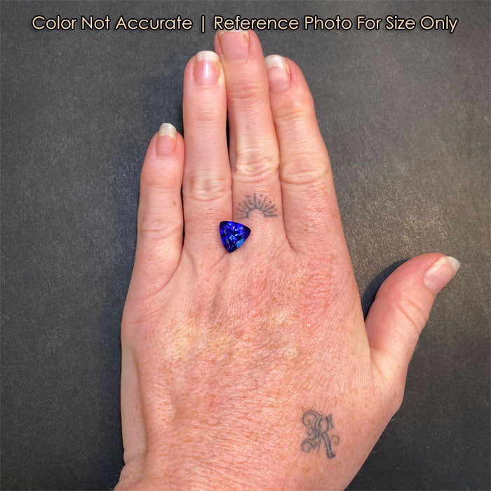 violet blue tanzanite on hand triliant shape