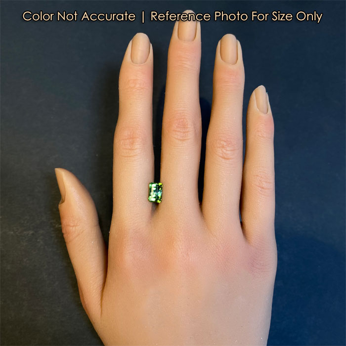 Green tourmaline gemstone on hand