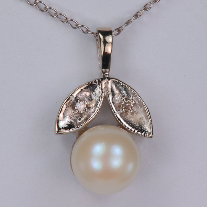 pearl necklace set in white gold with diamond accents and cable chain