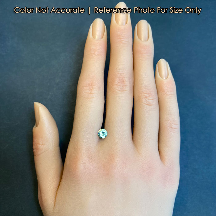 blue green demantoid garnet gem on hand