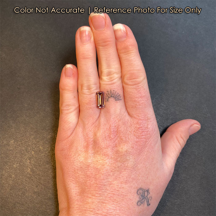pink emerald cut zircon on a hand