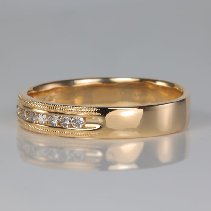 yellow gold ring with channel set diamonds and millgrain detail