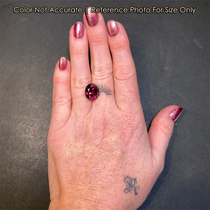 violet red oval garnet on hand