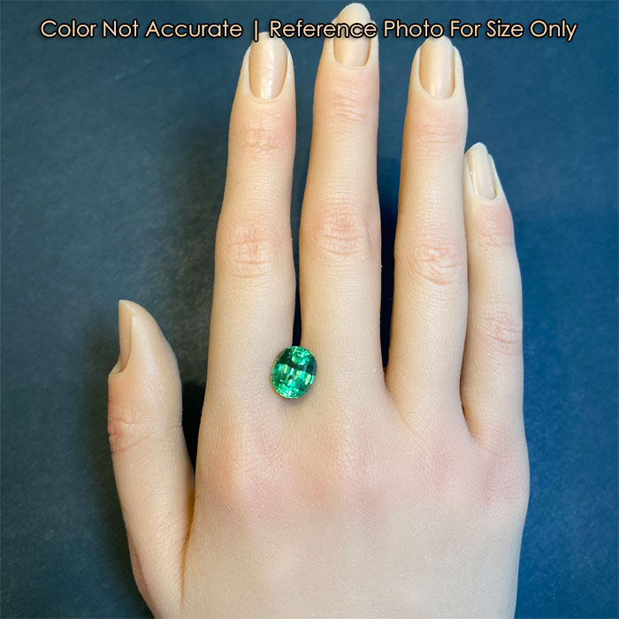 green oval garnet on hand