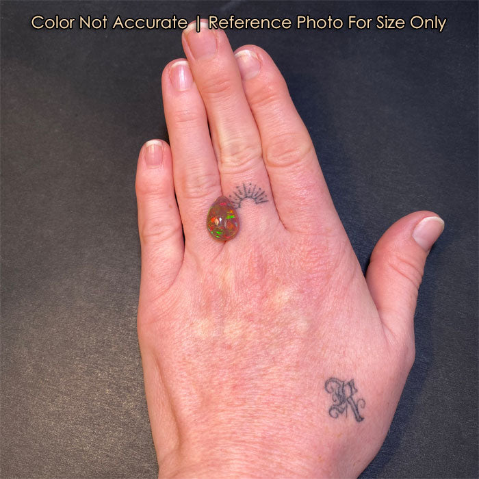 semi black opal gemstone on hand pear shape