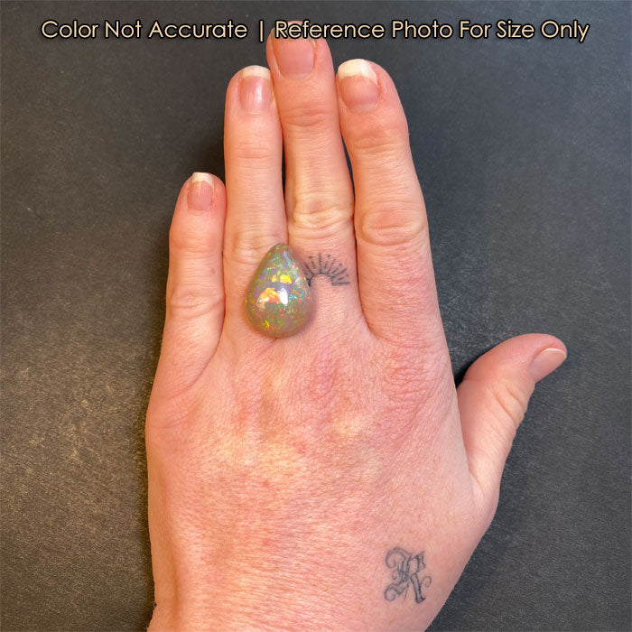 semi black opal gemstone pear shape on hand