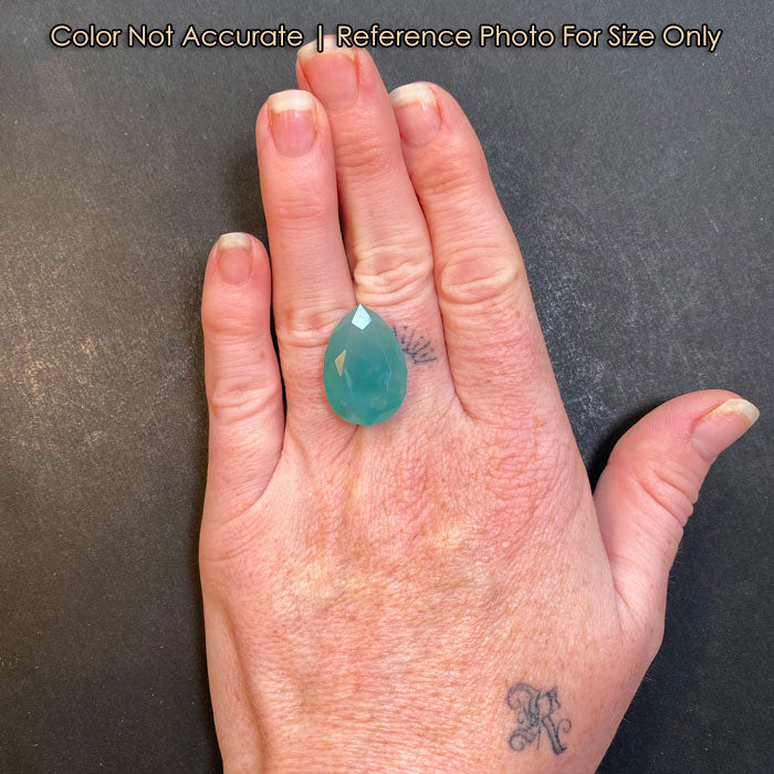 blue green pear shape chalcedony on hand size