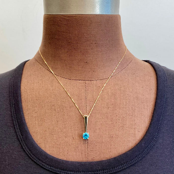 blue zircon pendant in yellow gold