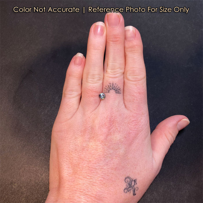 round sapphire gemstone on hand