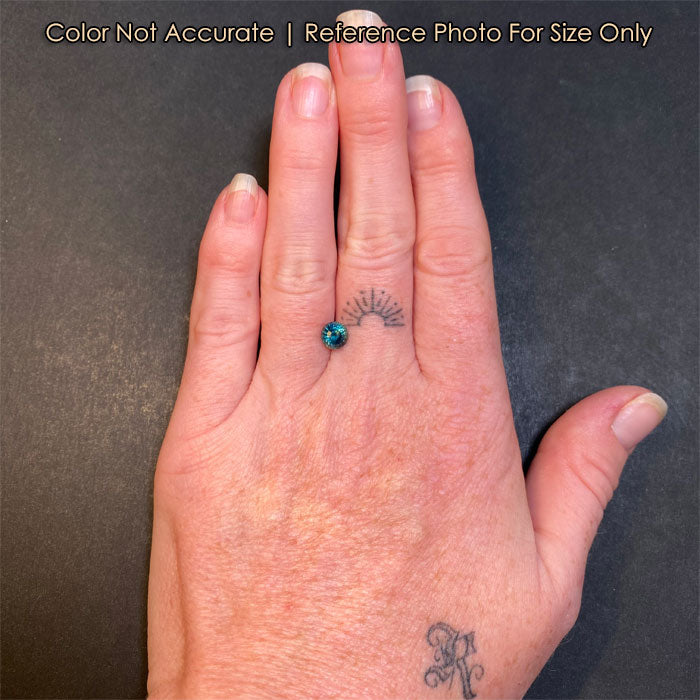 blue green sapphire gem on hand