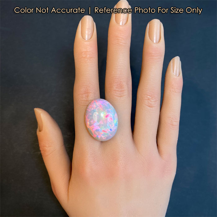 semi black oval opal on hand