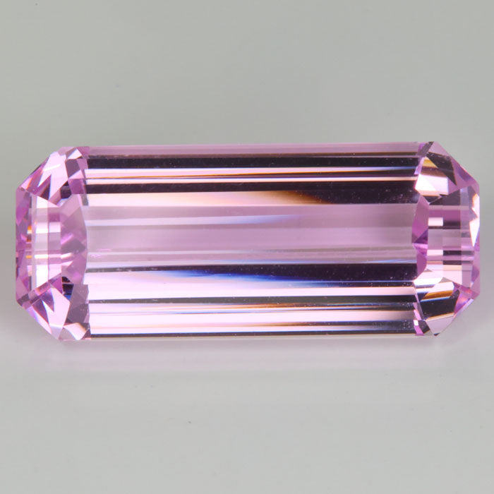 large emerald cut pink spodumene gemstone on hand 