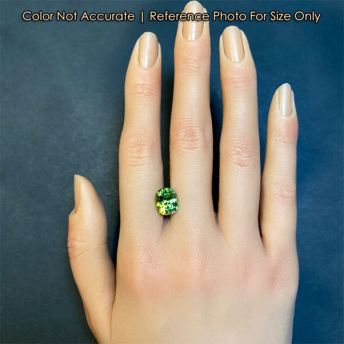 green color oval peridot on hand
