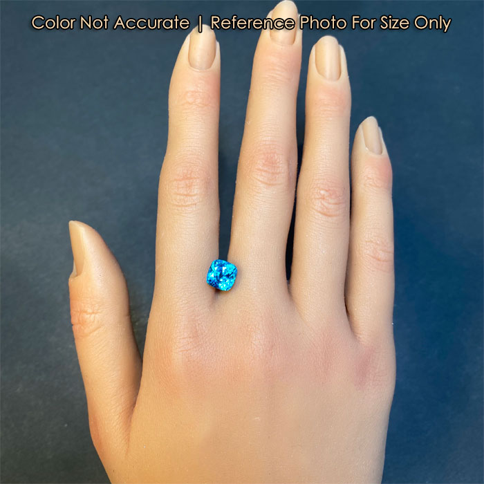 greenish blue zircon on hand reference