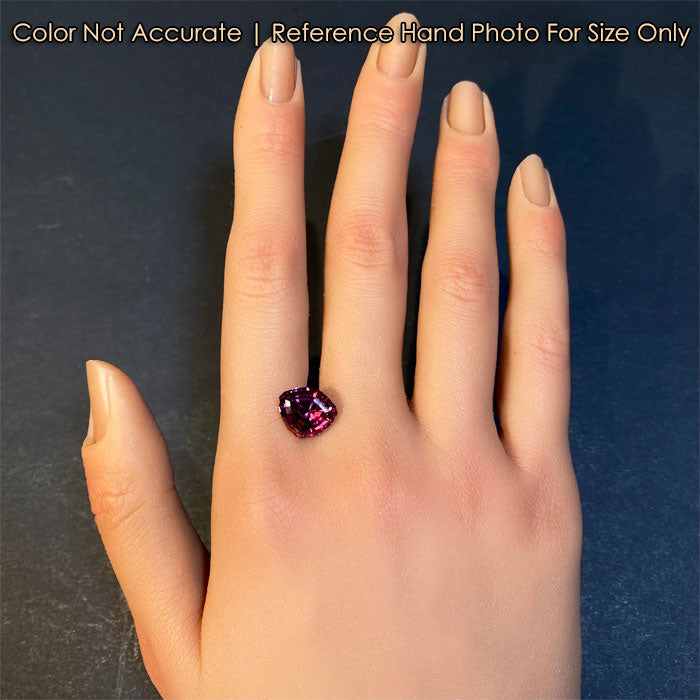 violet red garnet gem on hand
