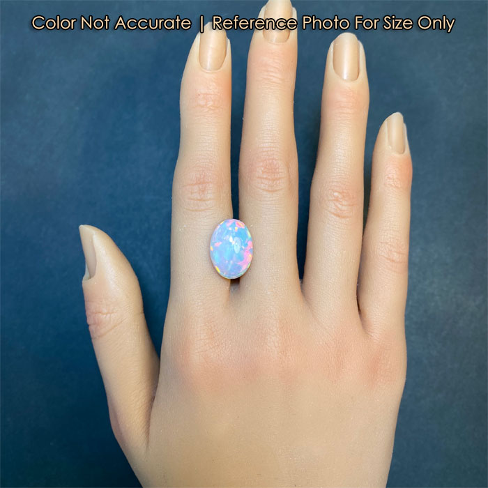 oval cabochon cut opal on hand for size