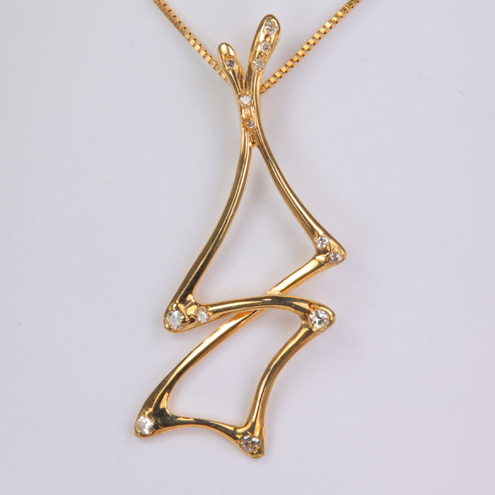 yellow gold pendant with abstract shape and diamonds