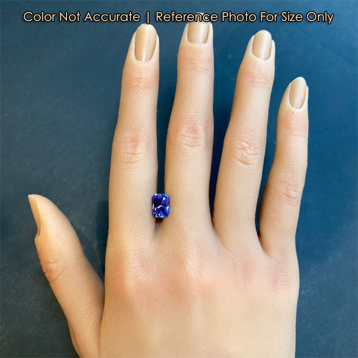 violet brilliant style emerald cut tanzanite on hand size