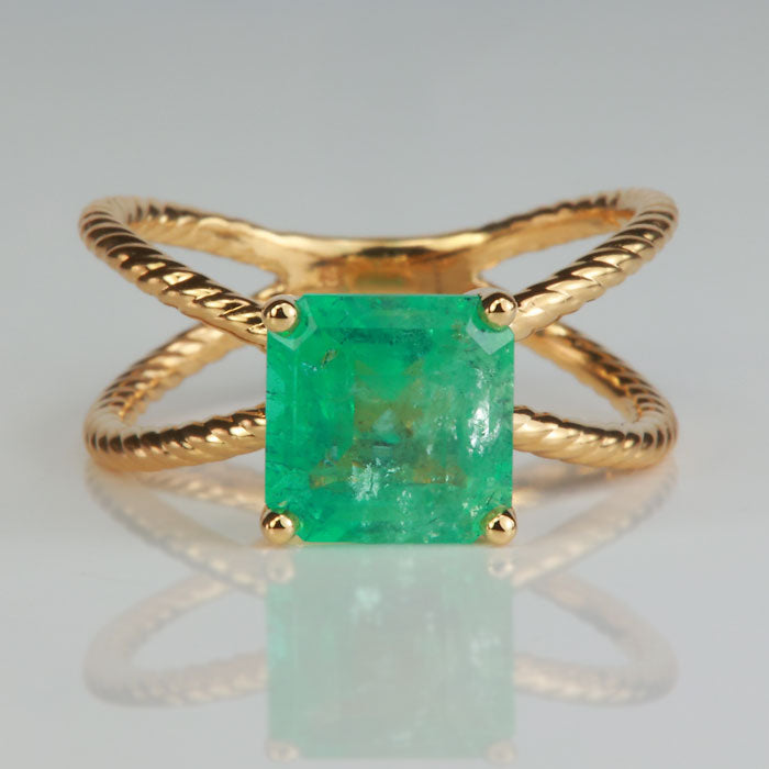 yellow gold criss cross ring with emerald gemstone square step cut