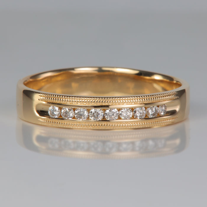 yellow gold ring with channel set diamonds and millgrain detail
