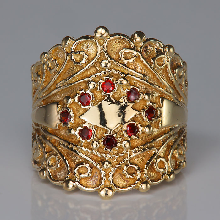 yellow gold garnet ring with ornate scroll detail