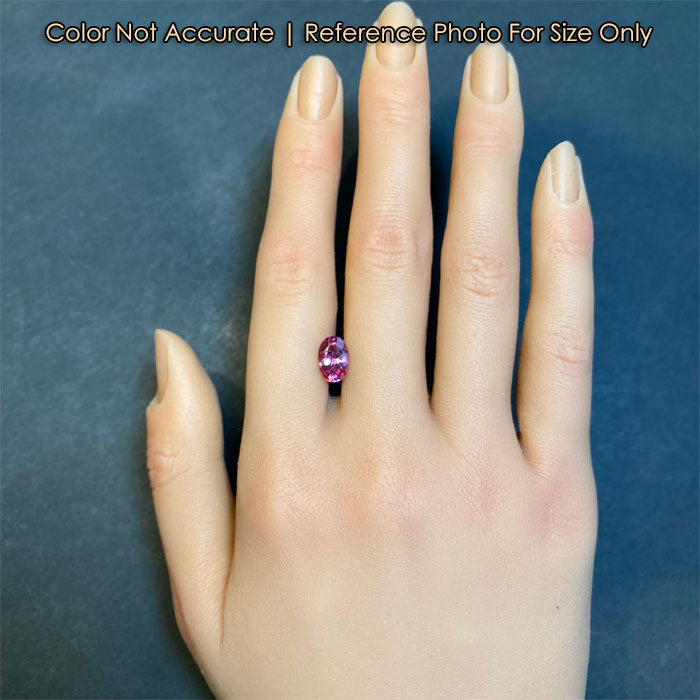 pink oval cut spinel gemstone on hand size 
