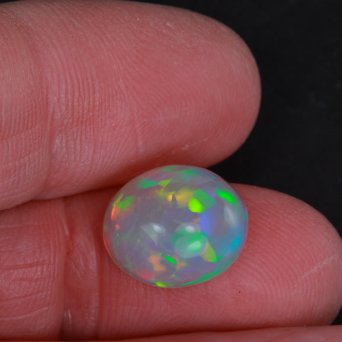 oval cabochon opal in hand