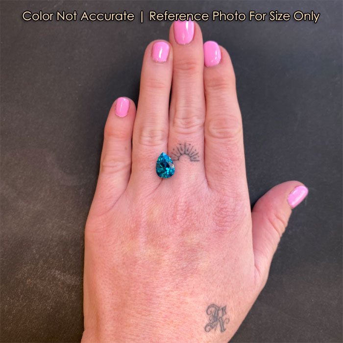 greenish blue zircon gemstone on hand