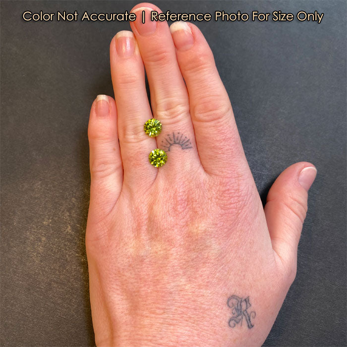 green round peridot gems on hand