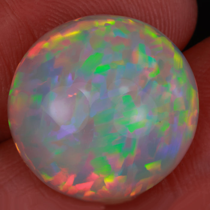 opal gemstone in hand round cut