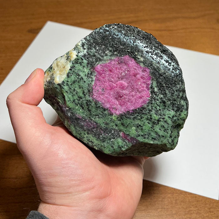 large zoisite with ruby size in hand