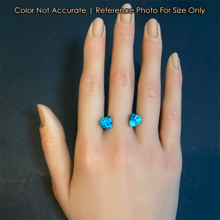 blue zircon gemstone pair size reference on hand 