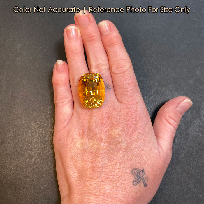 yellow step cut scapolite gemstone on hand size reference