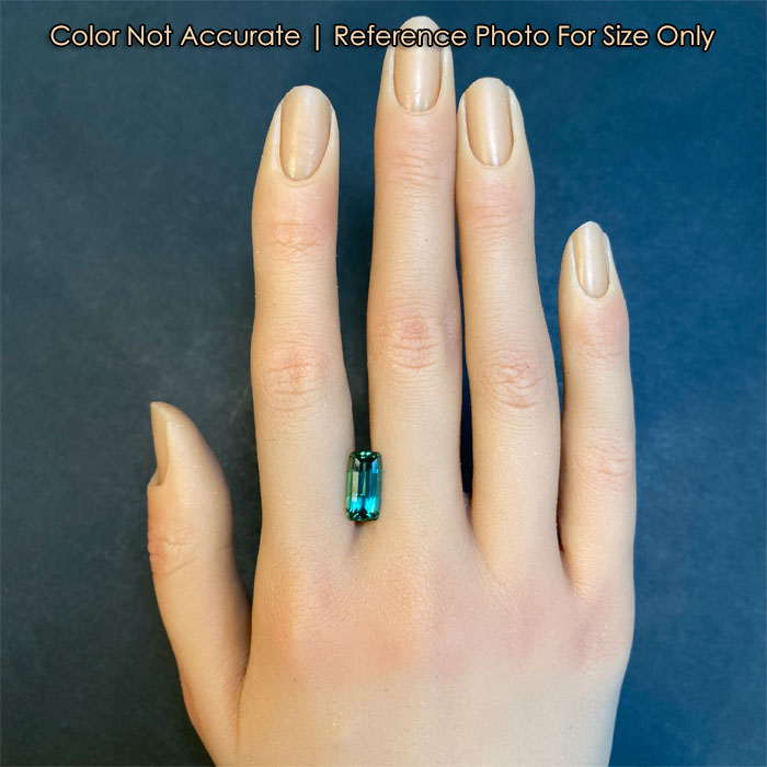 blue green tourmaline gem on hand