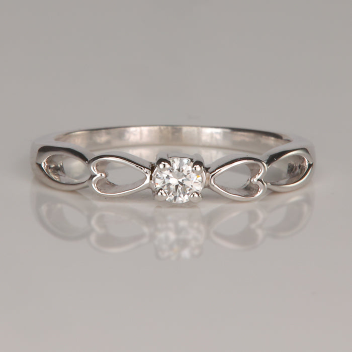 white gold ring with heart details and diamond