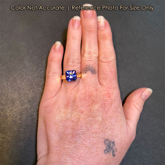 tanzanite square cut ring on hand in yellow gold