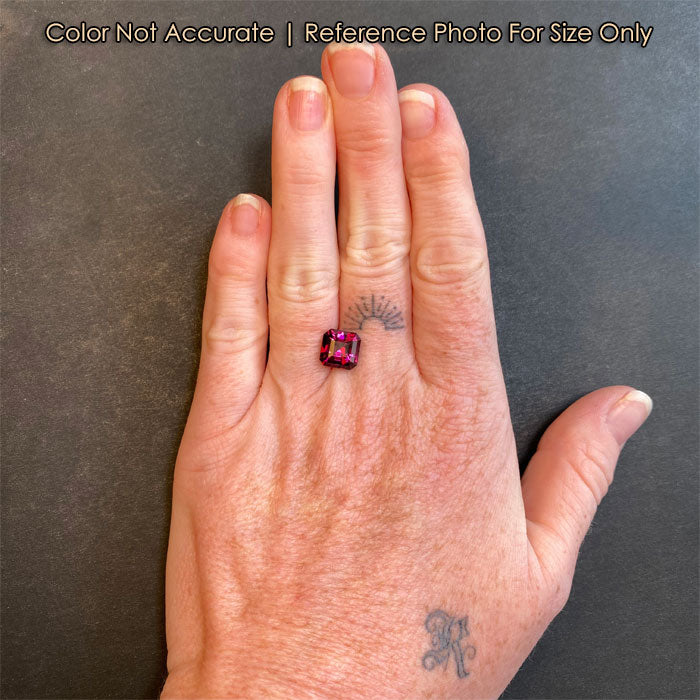 violet red garnet gemstone on hand