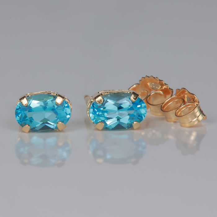 yellow gold oval cut blue topaz stud earrings