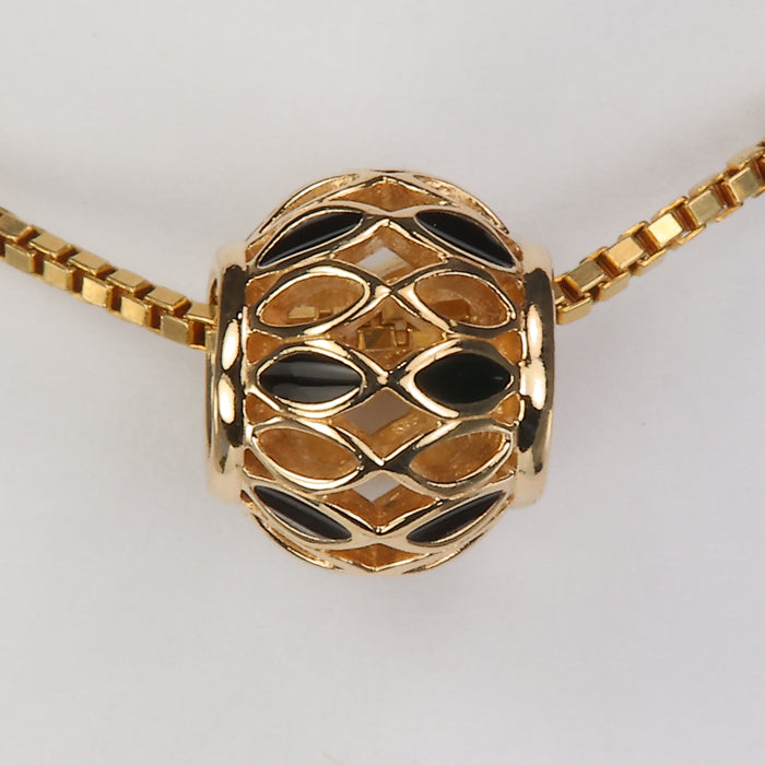 yellow gold bead with black enamel