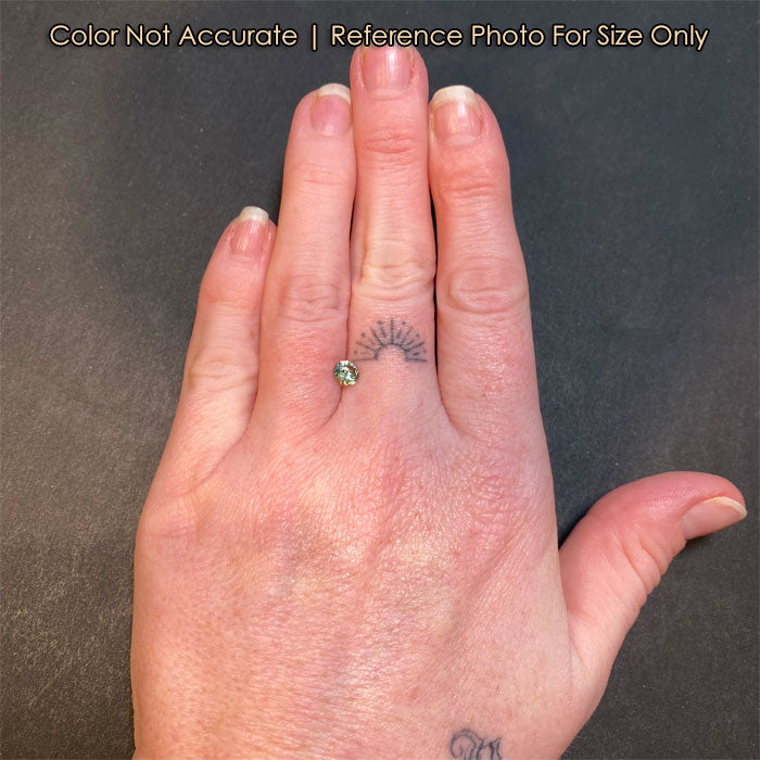 round brilliant sapphire gem on hand