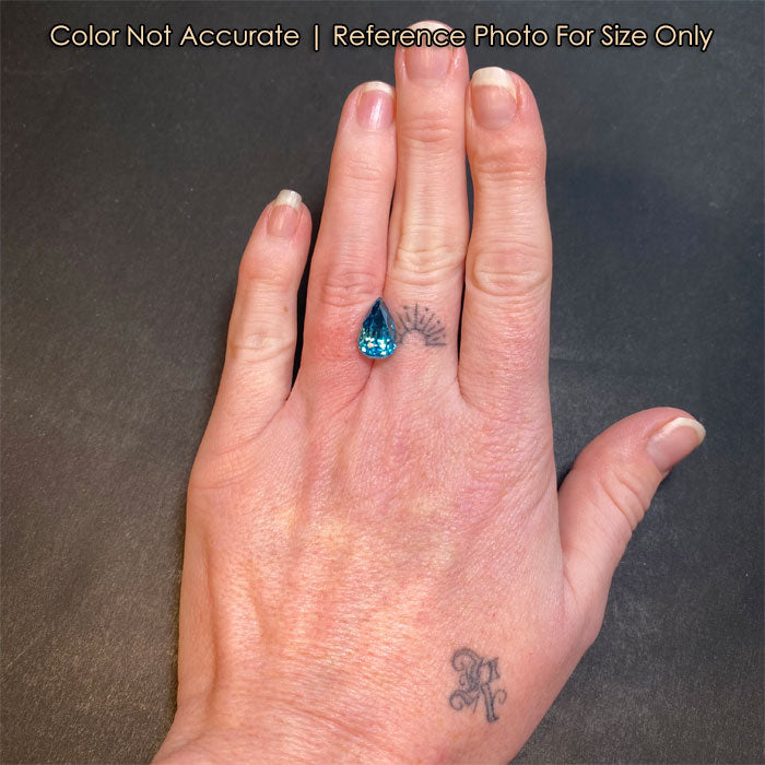 pear shape blue zircon gem on hand